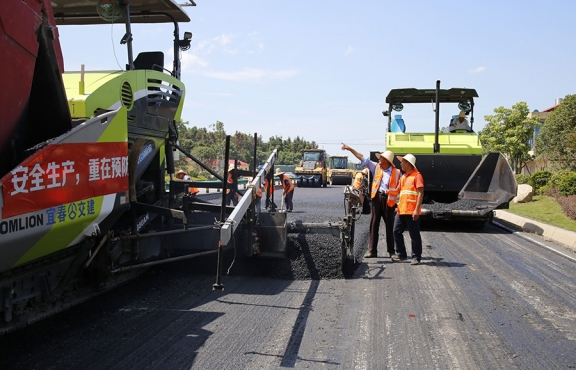 攤鋪機(jī)、壓路機(jī)等設(shè)備緊張有序運(yùn)行，高達(dá)170℃的瀝青混合料炙烤著公路人